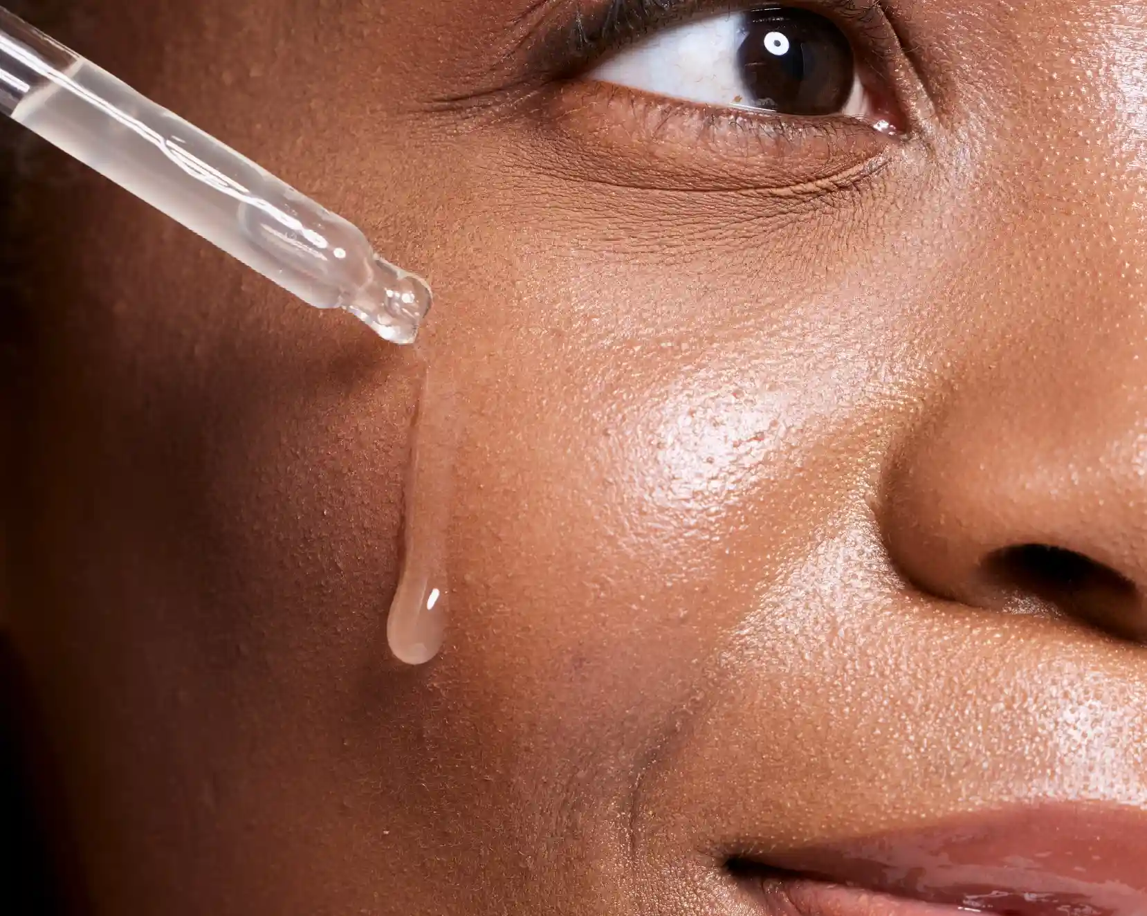 Mujer colocándose serum facial en el rostro
