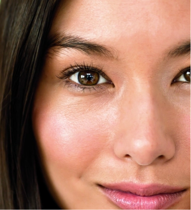 Mujer con piel luminosa e hidratada como resultado de aplicarse una rutina facial verano escogida por nuestros especialistas